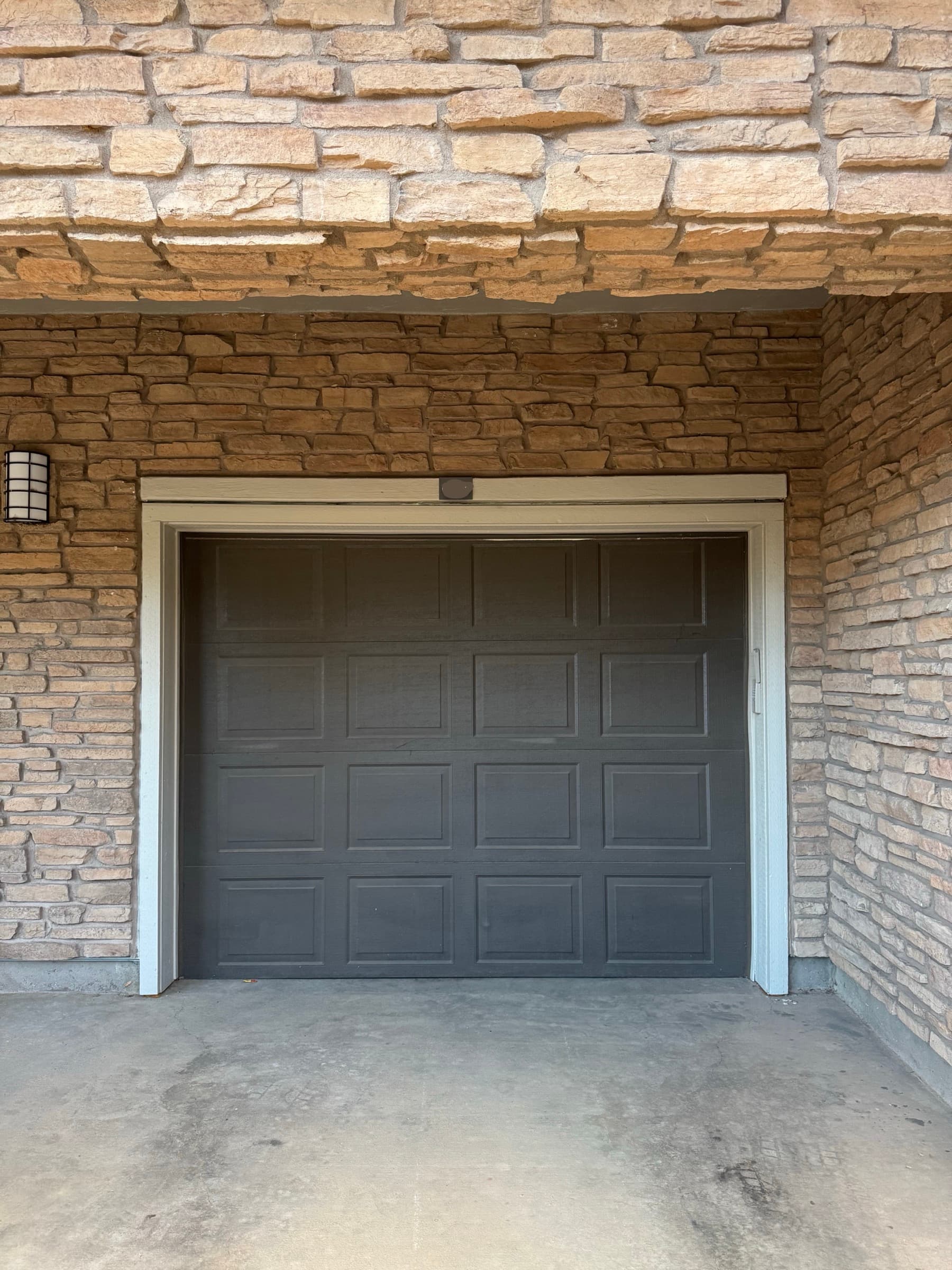 Garage door serviced by Black Swan Repairs on a stone facade, Denver Front Range