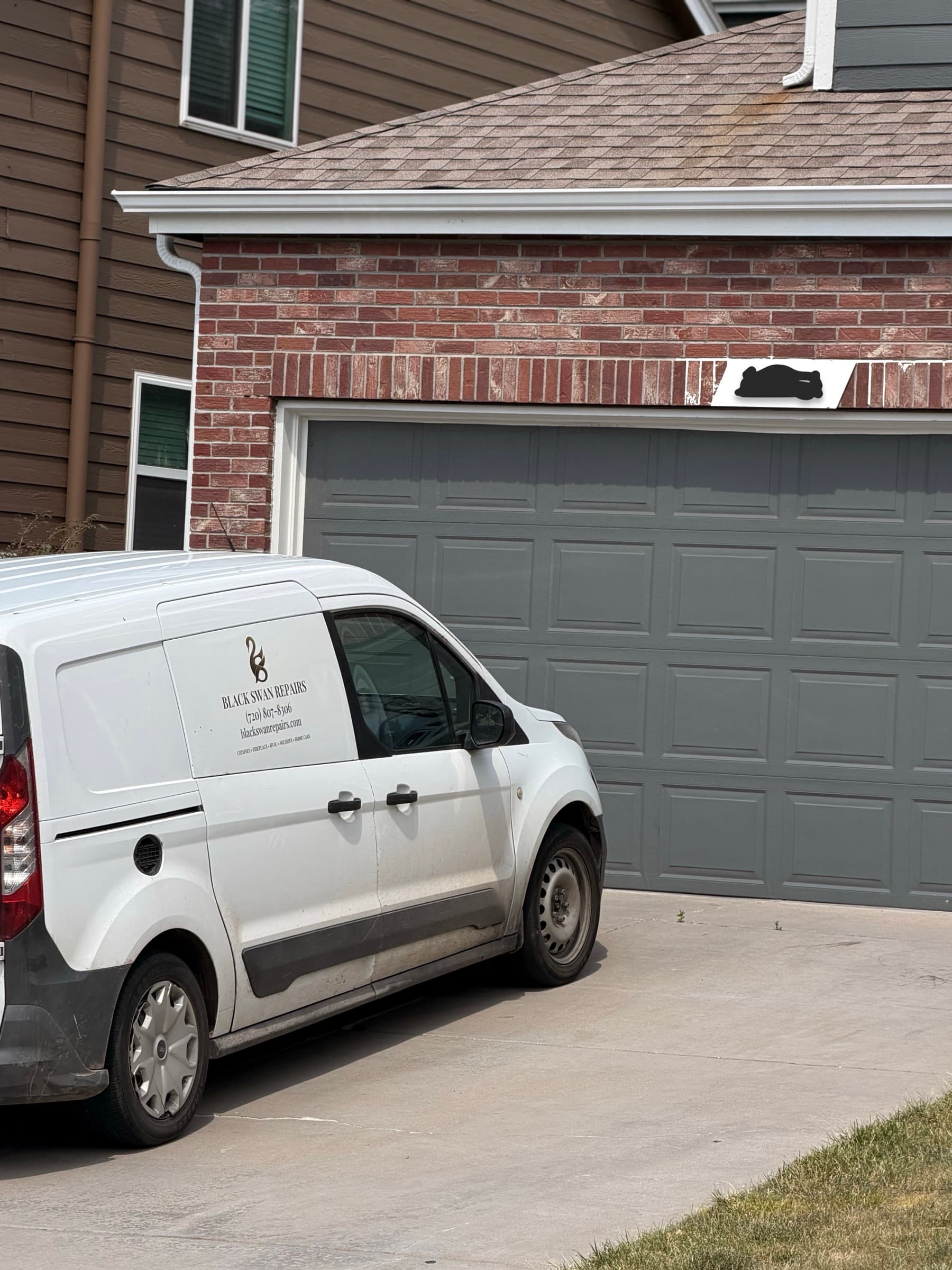 Black Swan Repairs service van on site at a residential garage door job