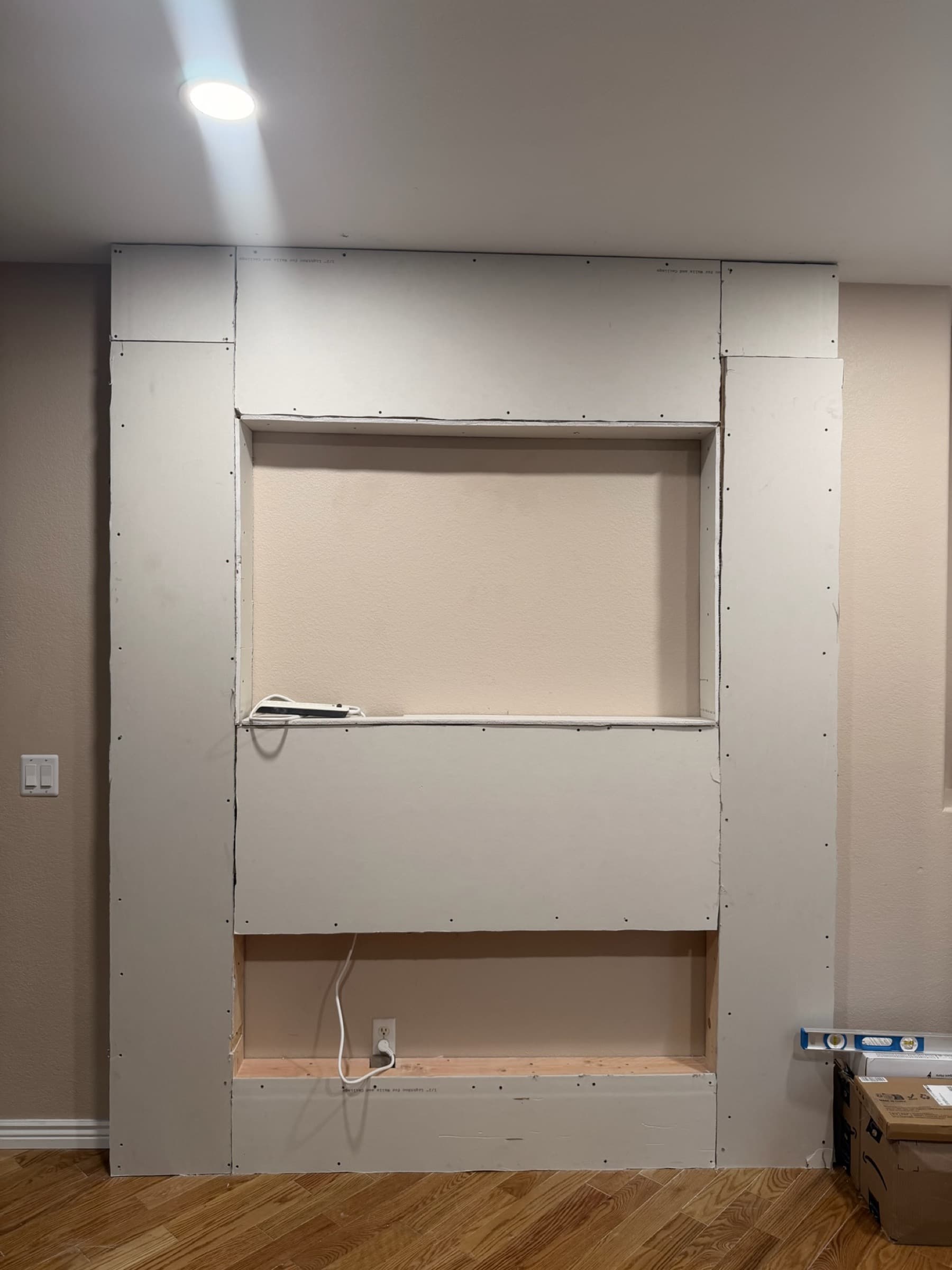 Framed and drywalled media wall structure with recessed niches, mid-build